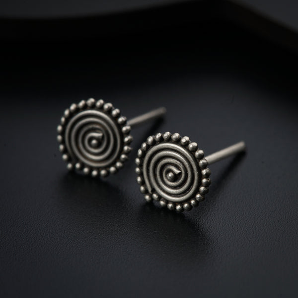 a pair of earrings sitting on top of a black surface