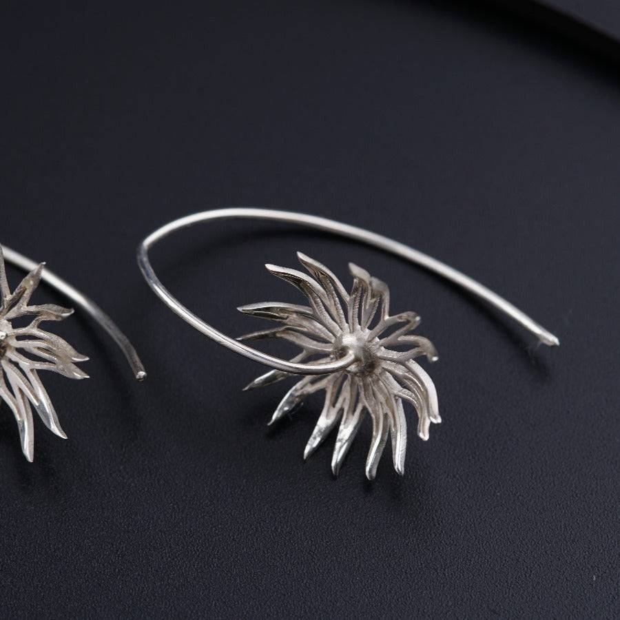 a close up of a pair of silver earrings