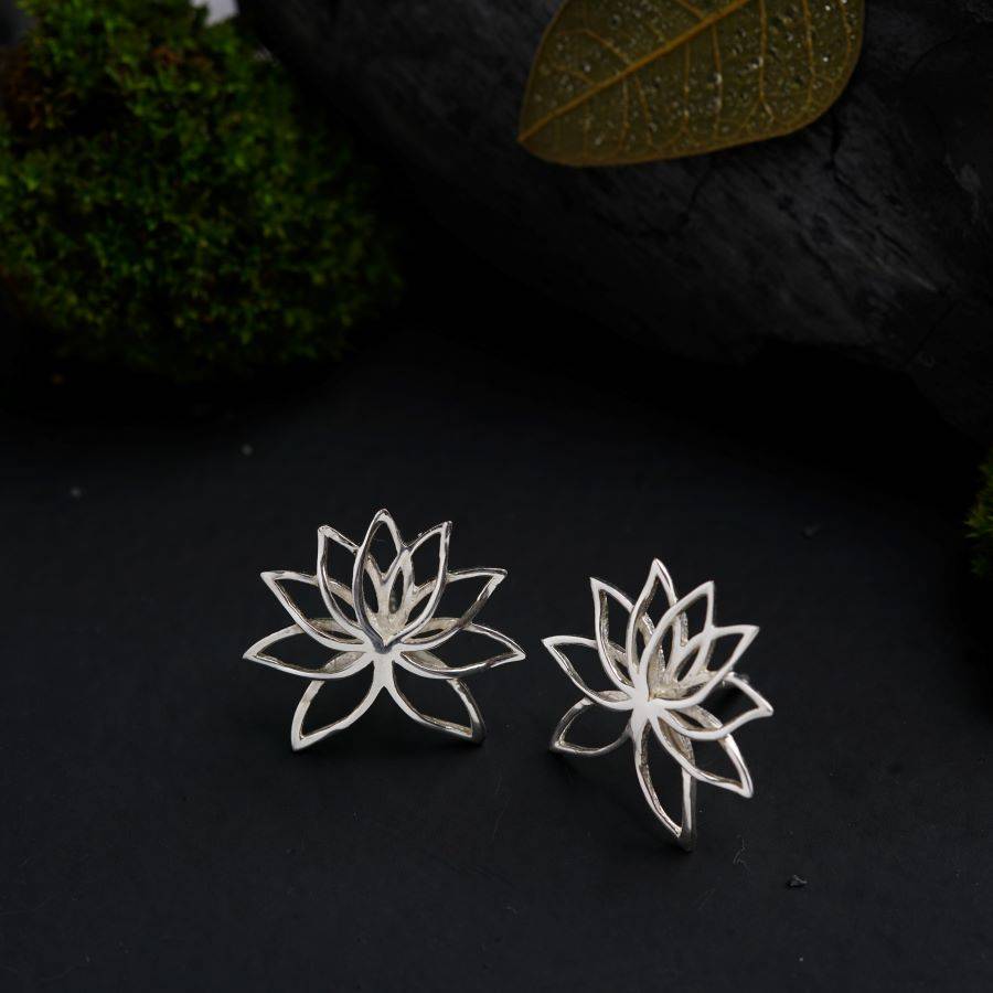 a pair of silver earrings with a flower design
