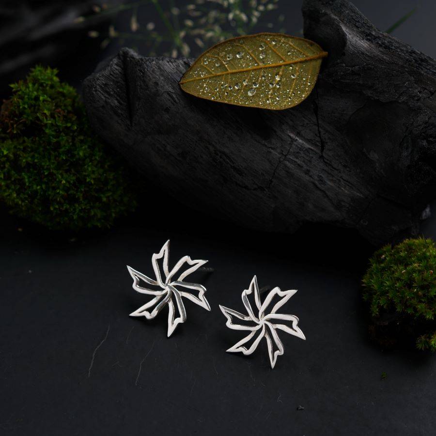 a pair of snowflake earrings sitting on top of a black surface