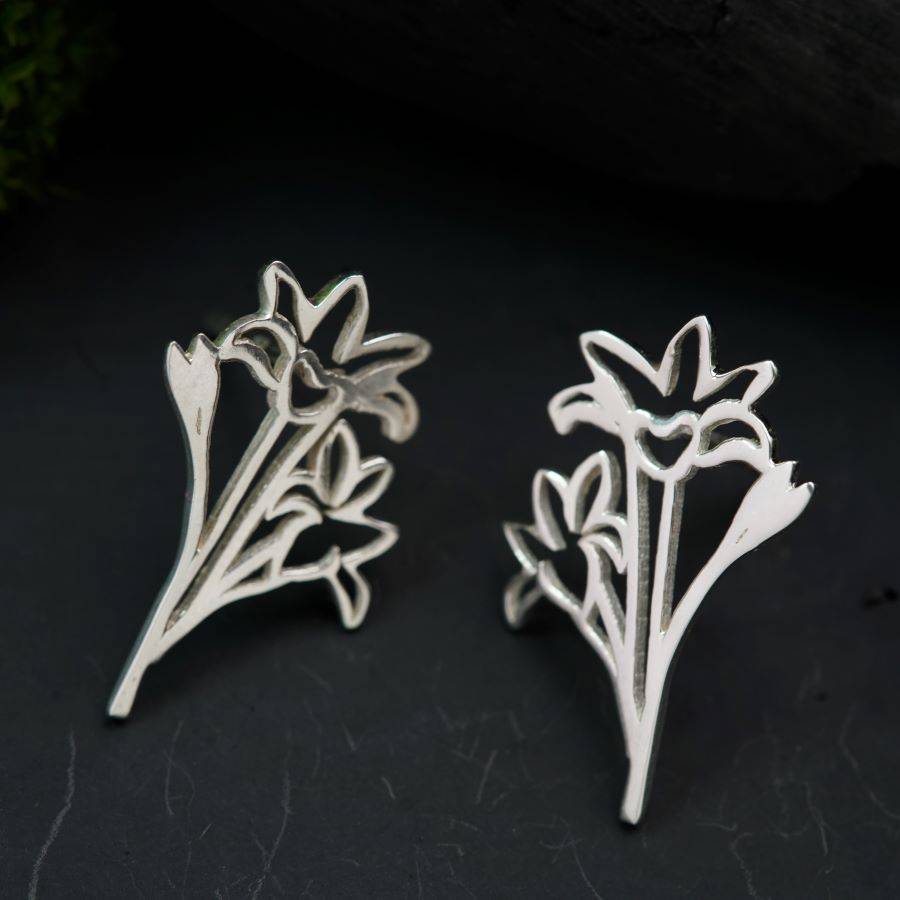 a pair of silver earrings with flowers on them