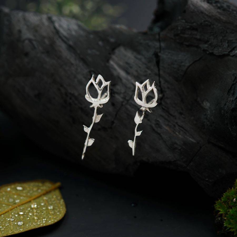 a pair of silver earrings with flowers on them