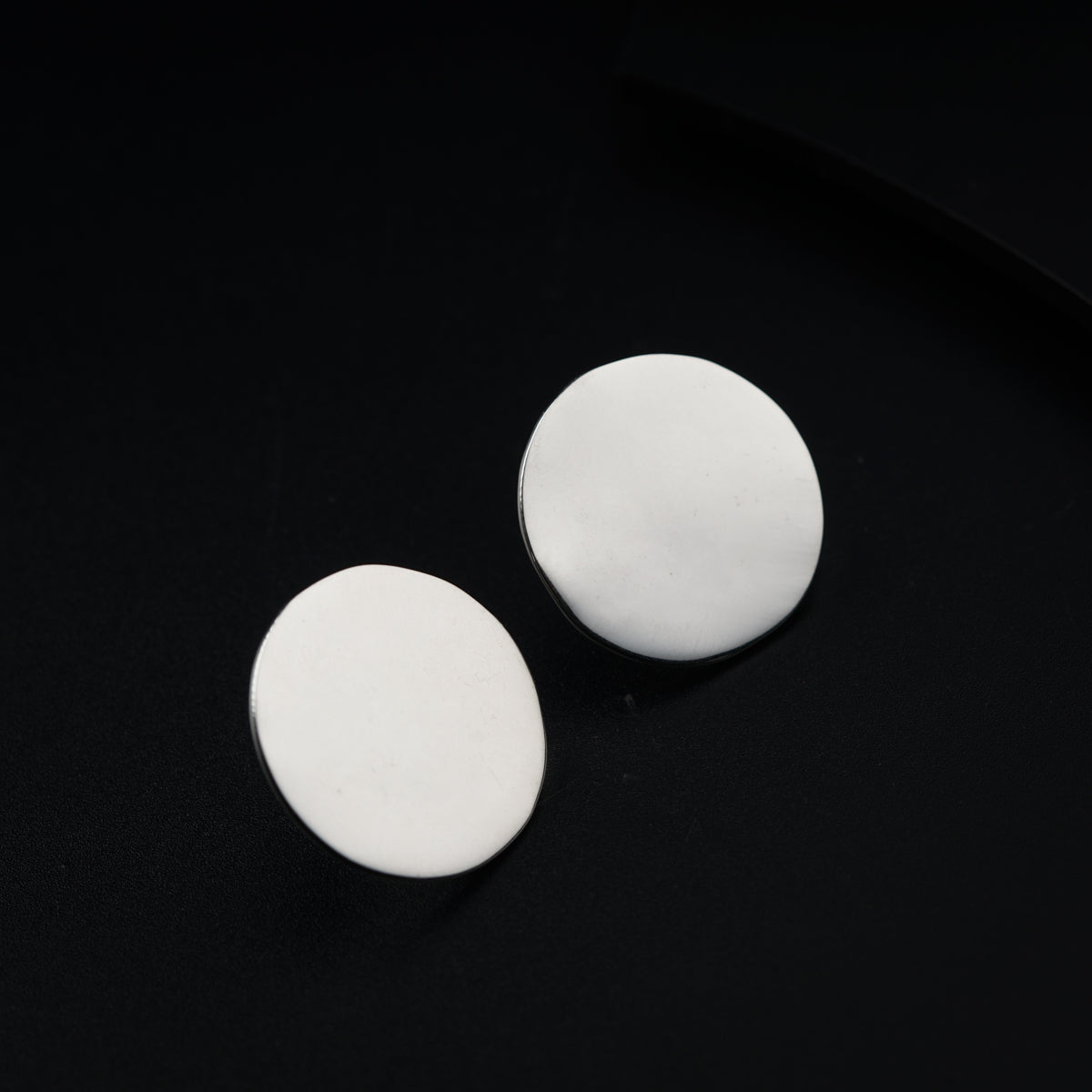 a pair of white buttons sitting on top of a black surface
