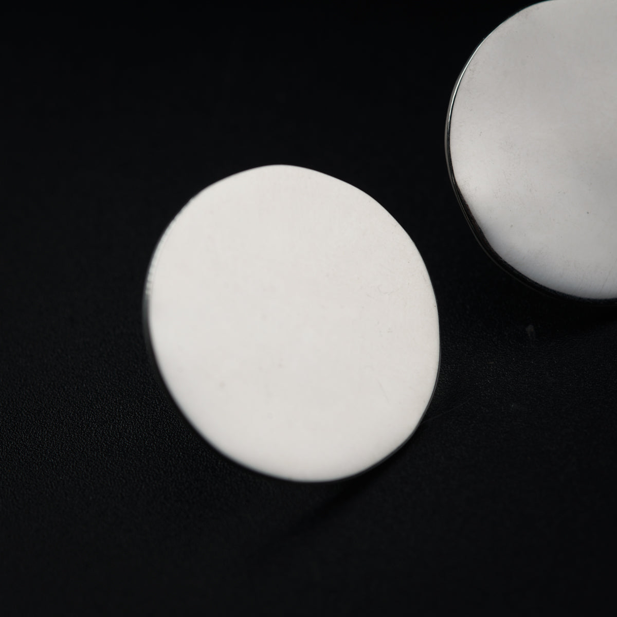 a pair of white buttons sitting on top of a black surface