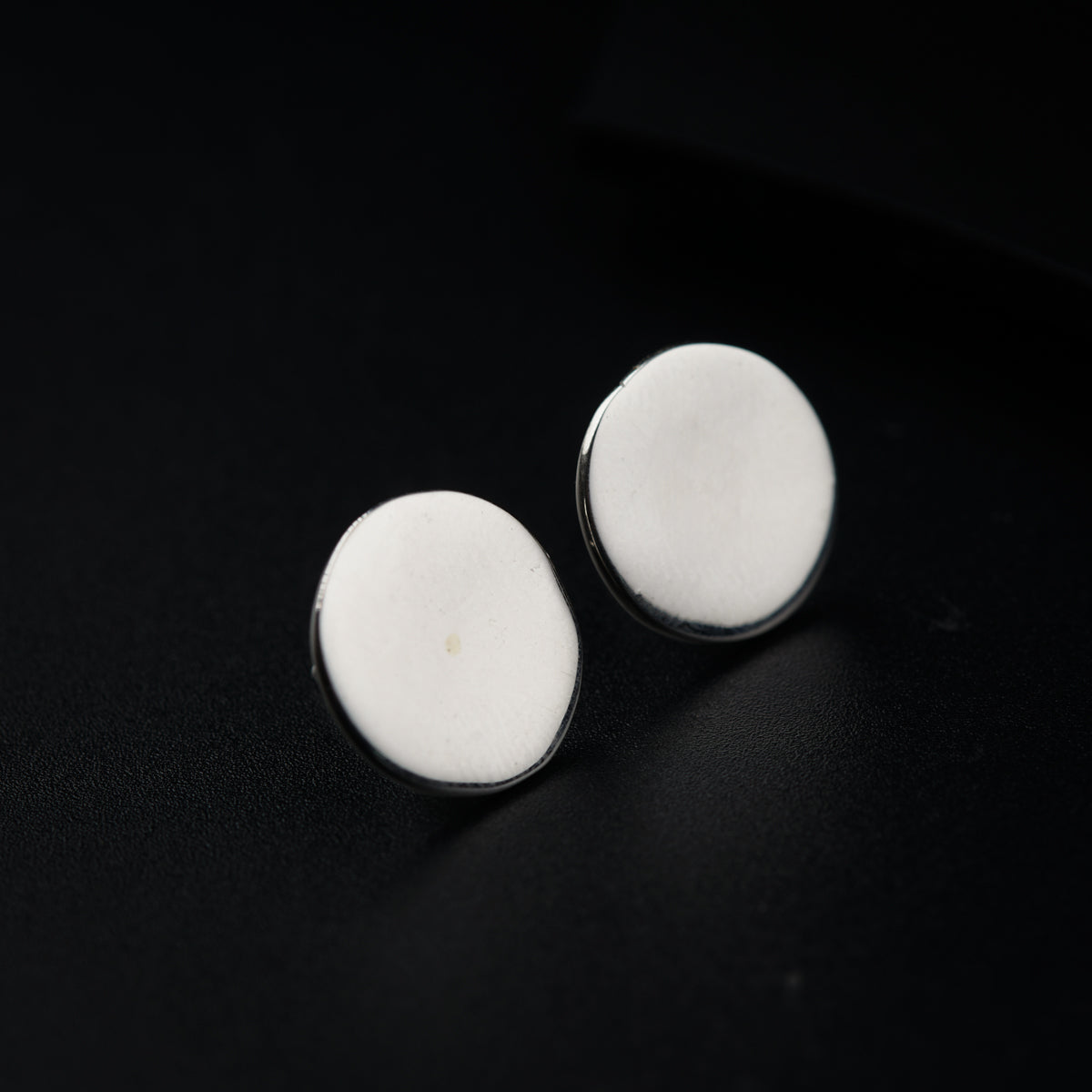 a pair of white buttons sitting on top of a black surface