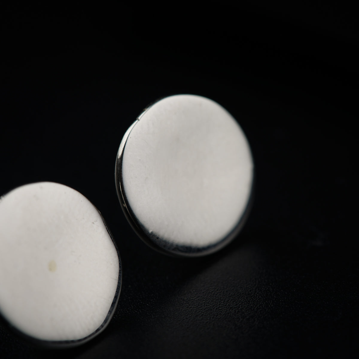 two white pills sitting on top of a black surface
