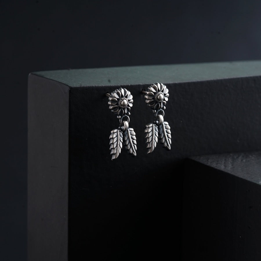 a pair of earrings hanging from the side of a wall
