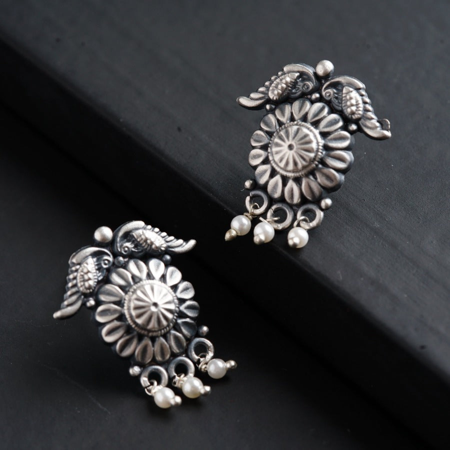 a close up of two earrings on a black surface