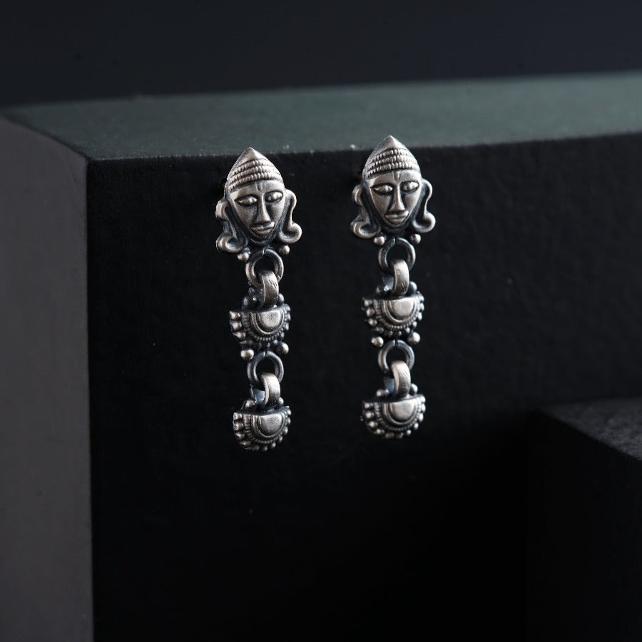 a pair of earrings with a face on it