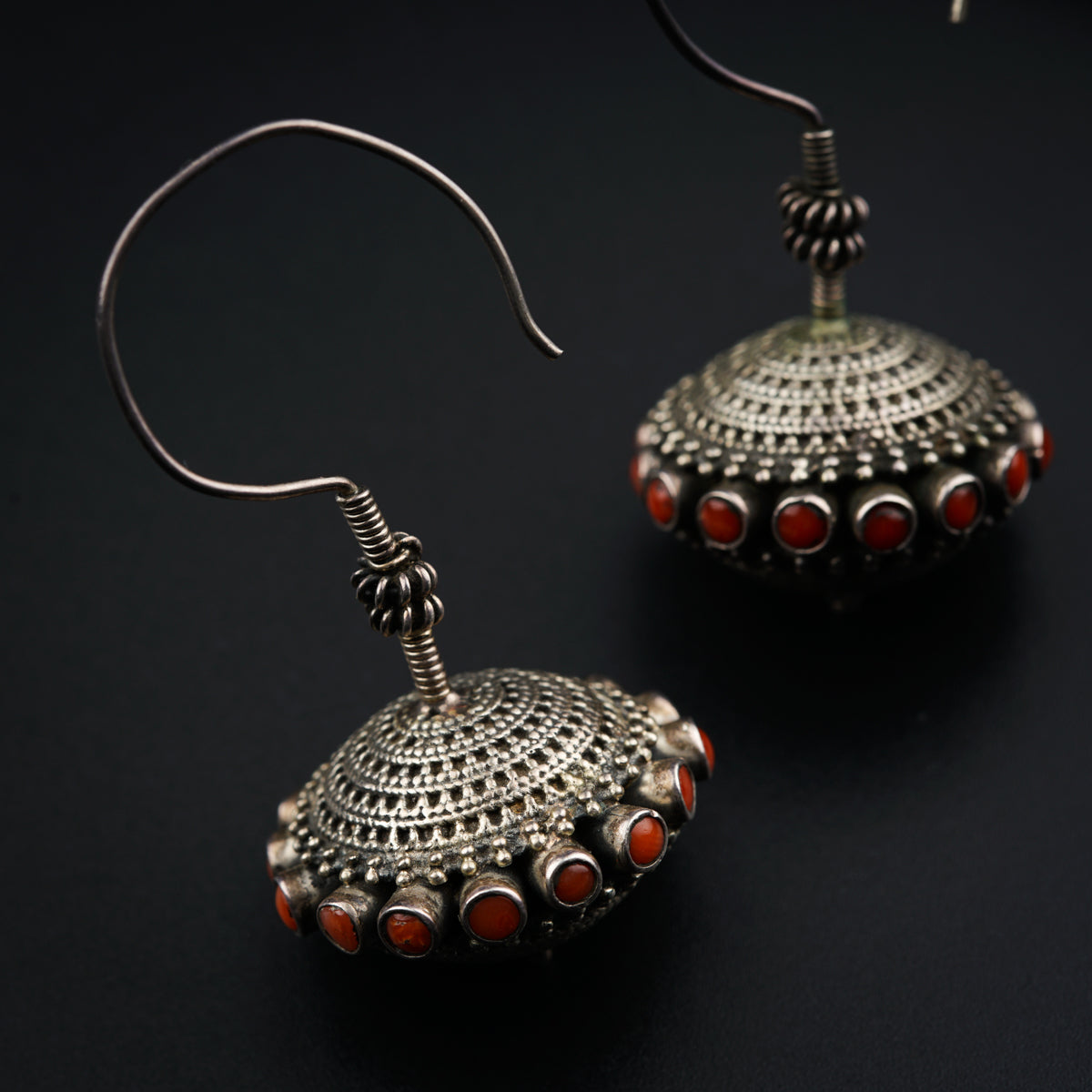 a pair of silver earrings with red stones