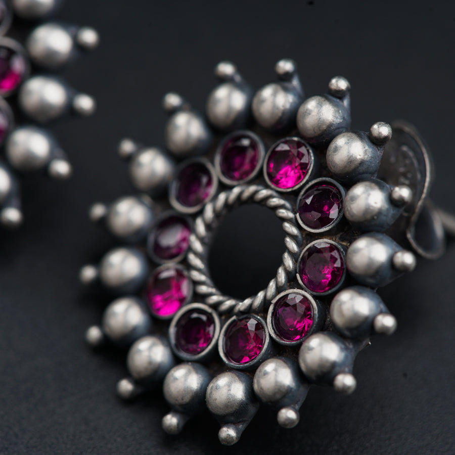a close up of a silver ring with pink stones