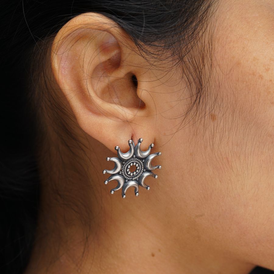 a close up of a person wearing a pair of earrings