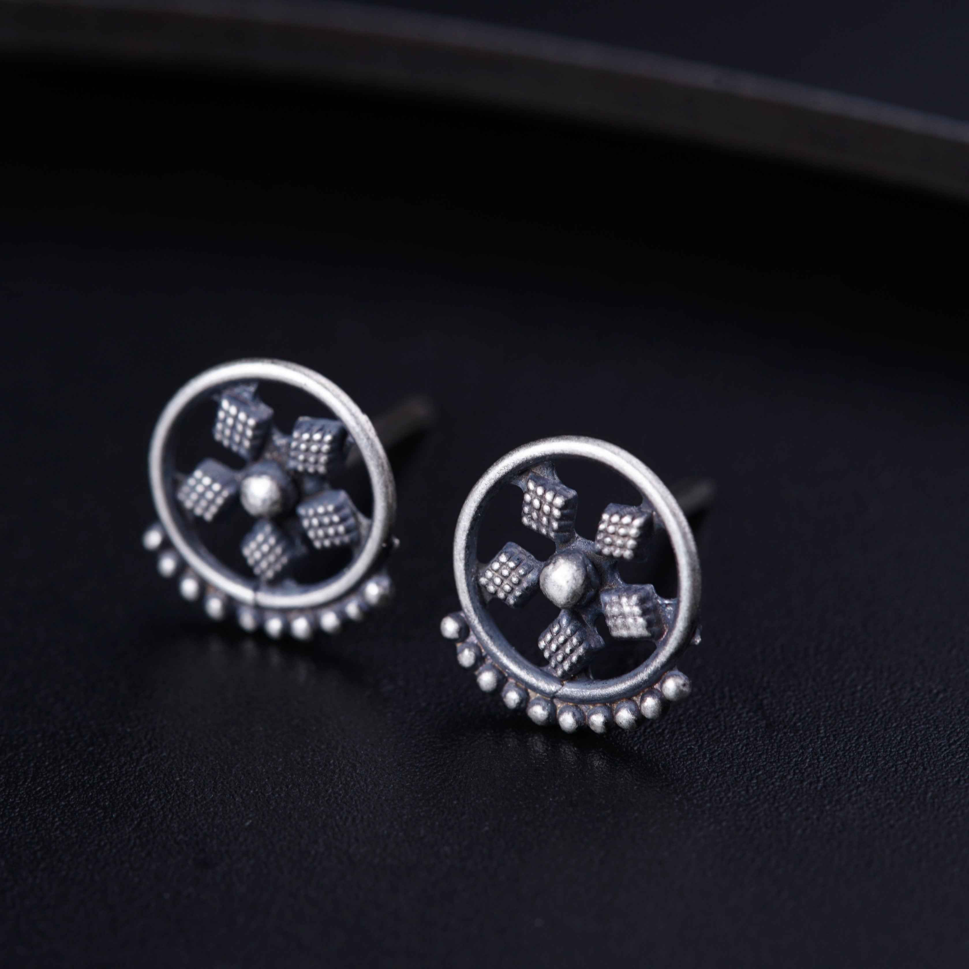 a pair of studded earrings sitting on top of a table