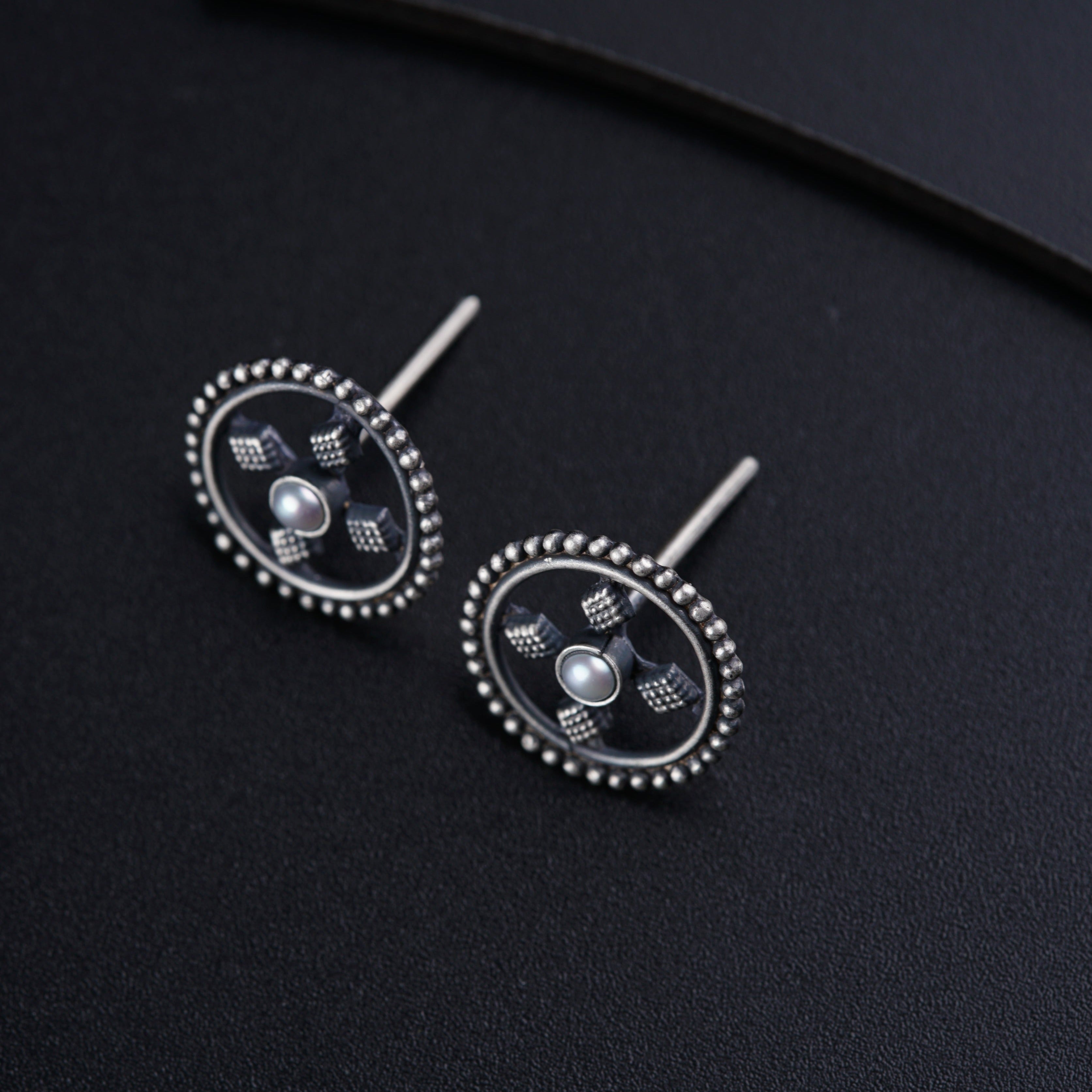 a pair of earrings on a black surface