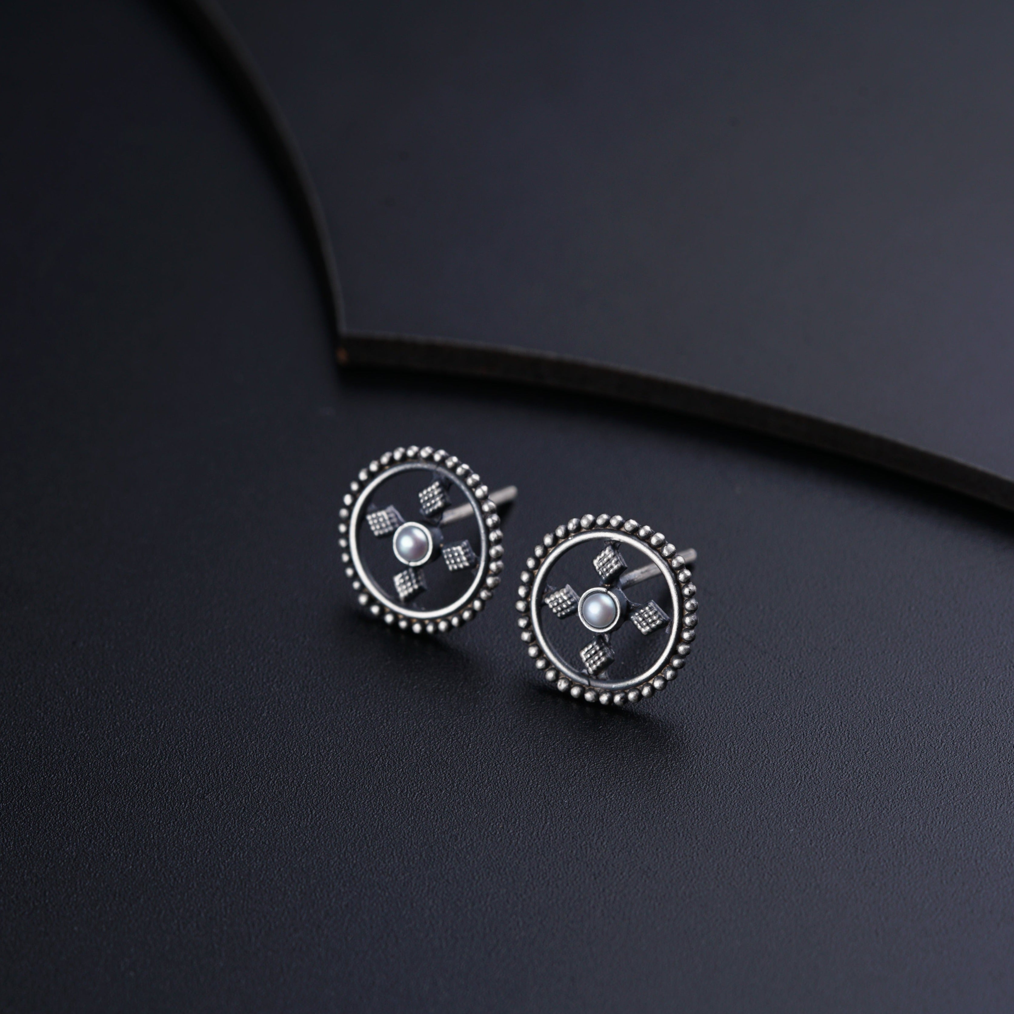 a pair of earrings on a black surface