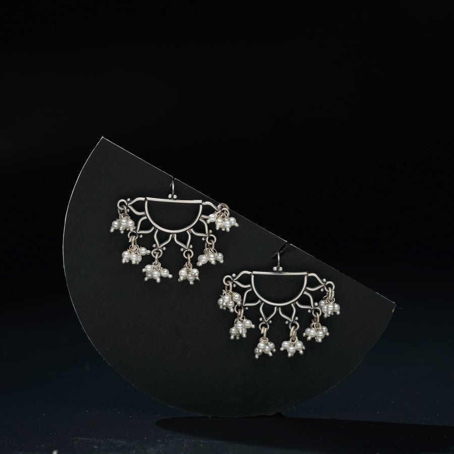 a pair of earrings sitting on top of a black surface