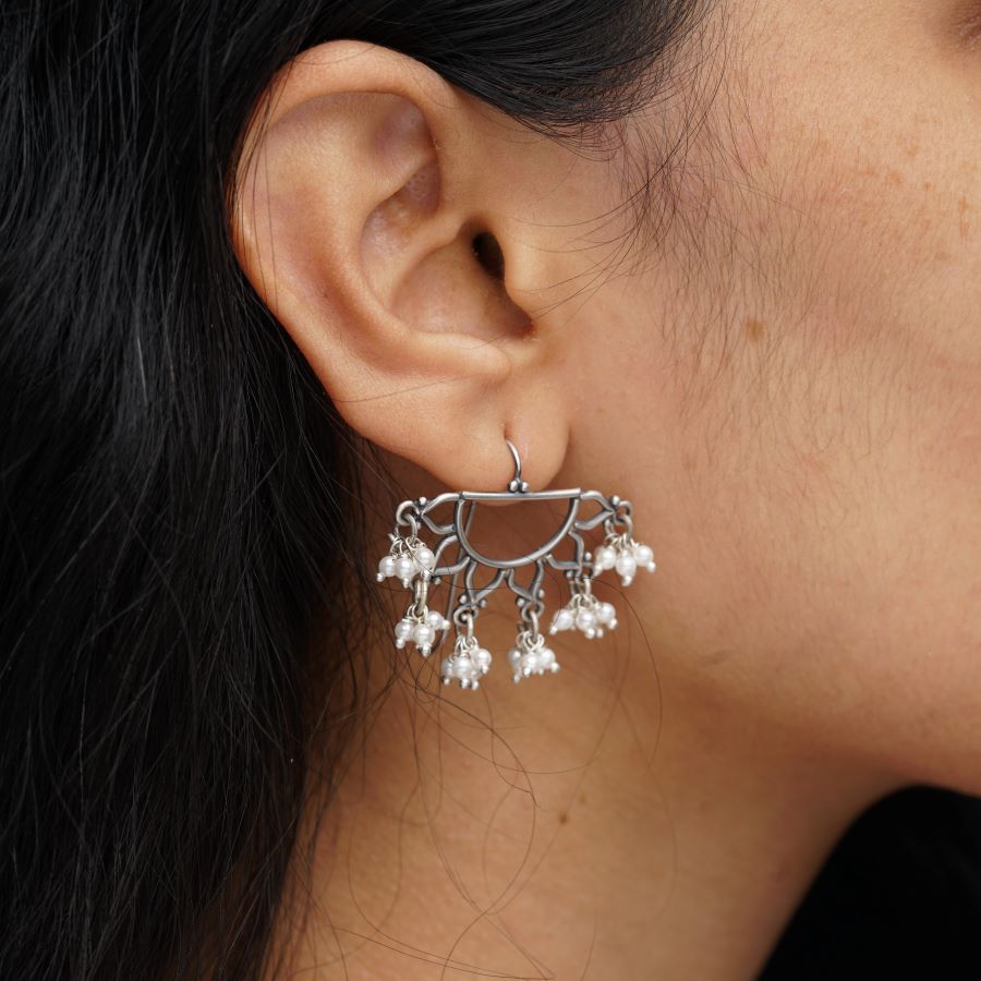 a close up of a person wearing a pair of earrings