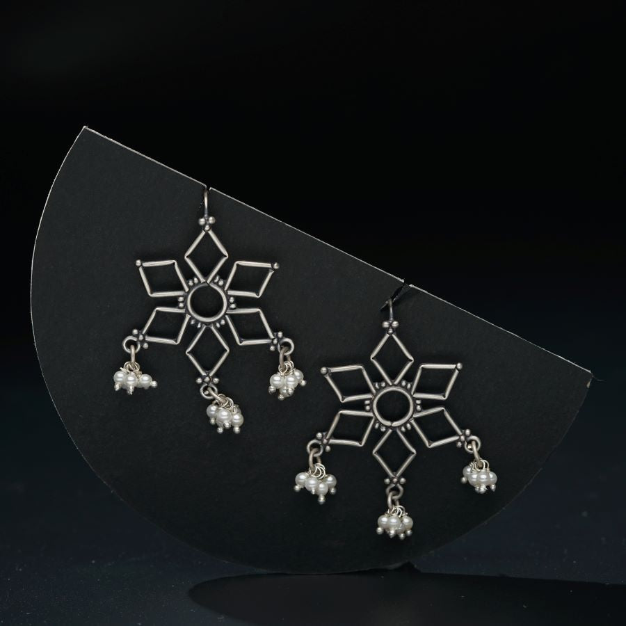 a pair of earrings on a black surface
