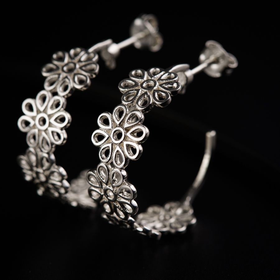 a close up of a pair of silver earrings