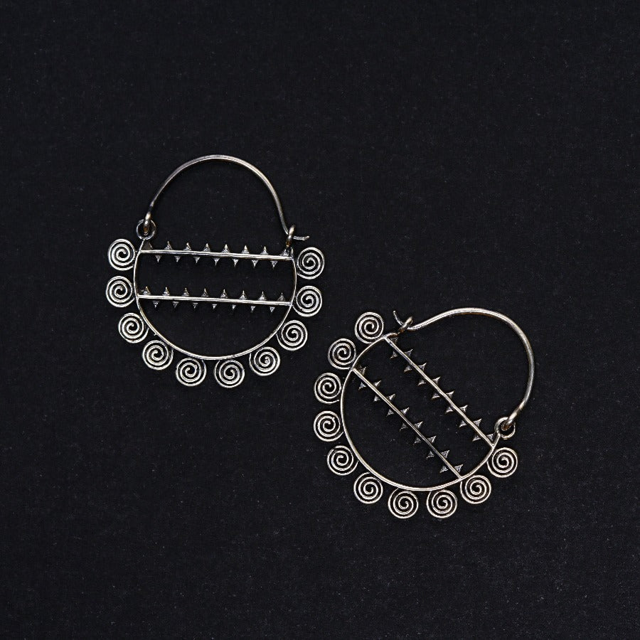 a pair of hoop earrings on a black surface