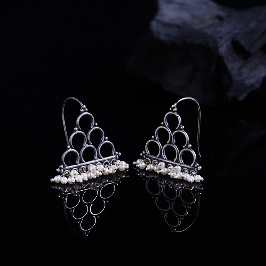 a pair of silver earrings with pearls