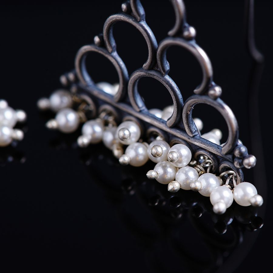 a tiara with pearls on a black surface