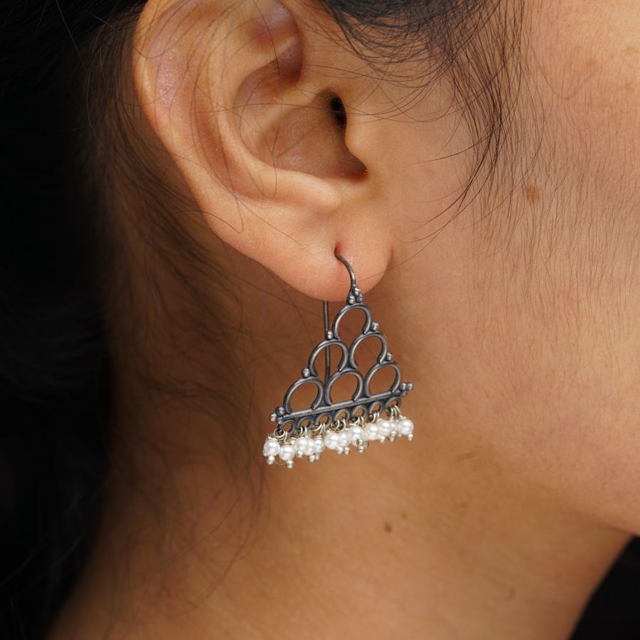a close up of a person wearing a pair of earrings