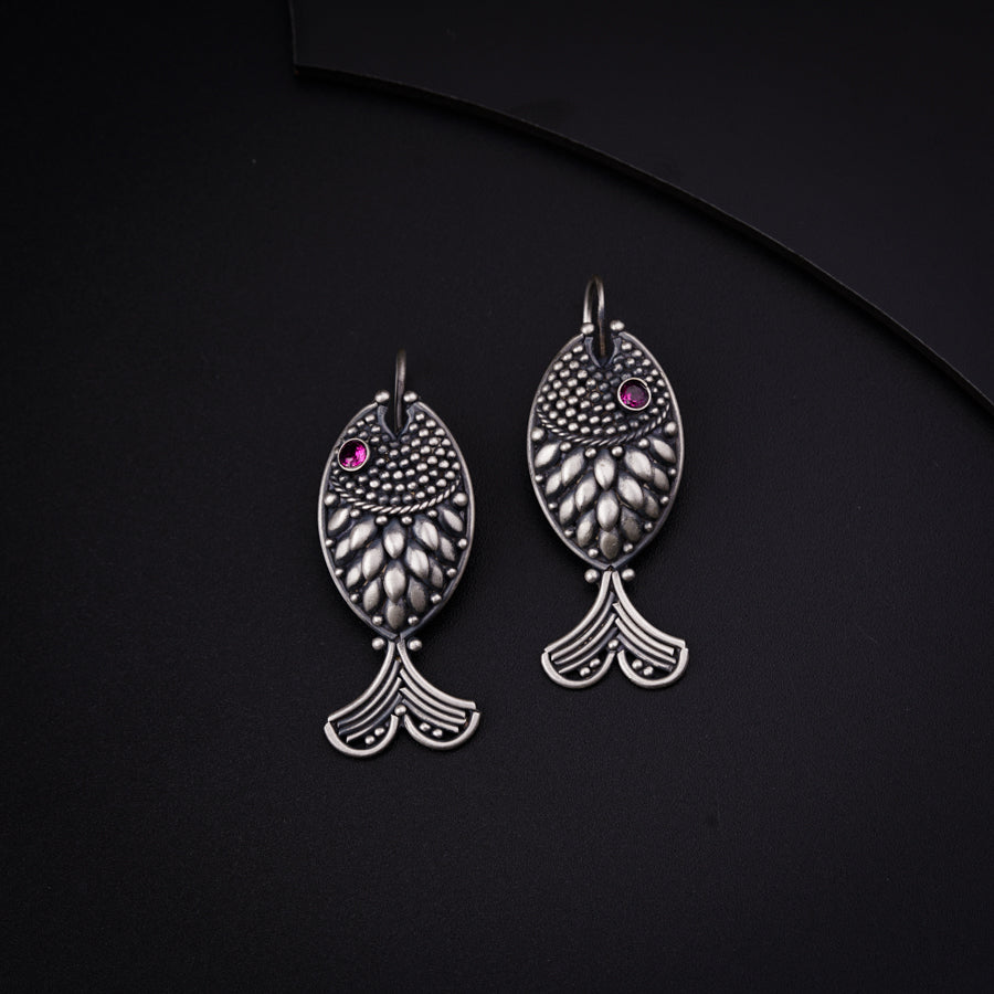 a pair of silver earrings with pink stones