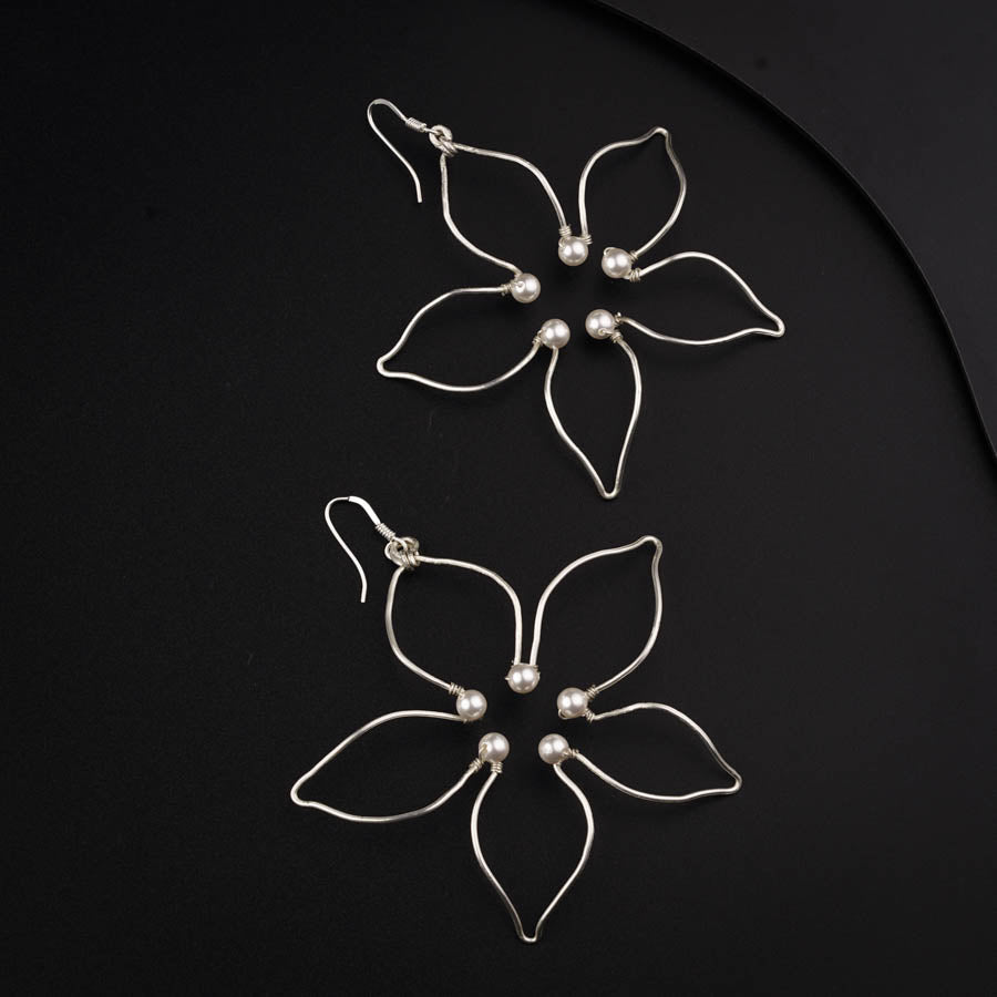 a pair of flower shaped hair pins on a black surface