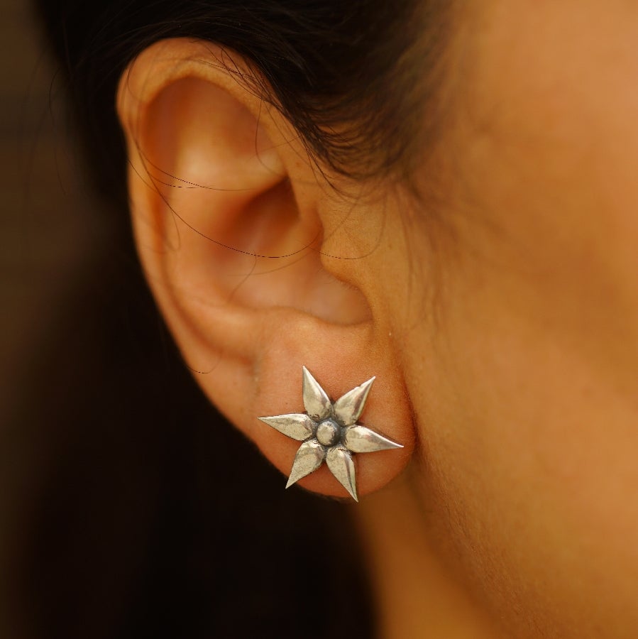 a close up of a person wearing a pair of earrings