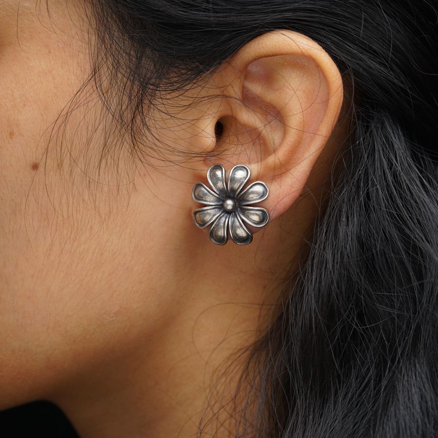a close up of a person wearing a pair of earrings