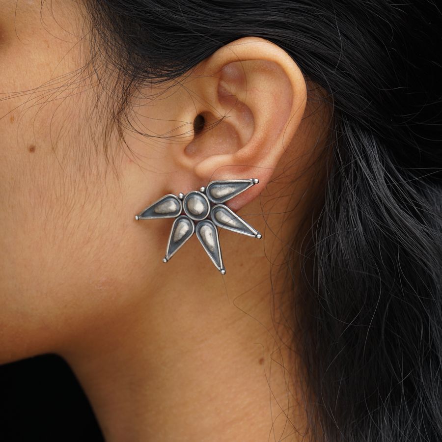 a close up of a person wearing a pair of earrings