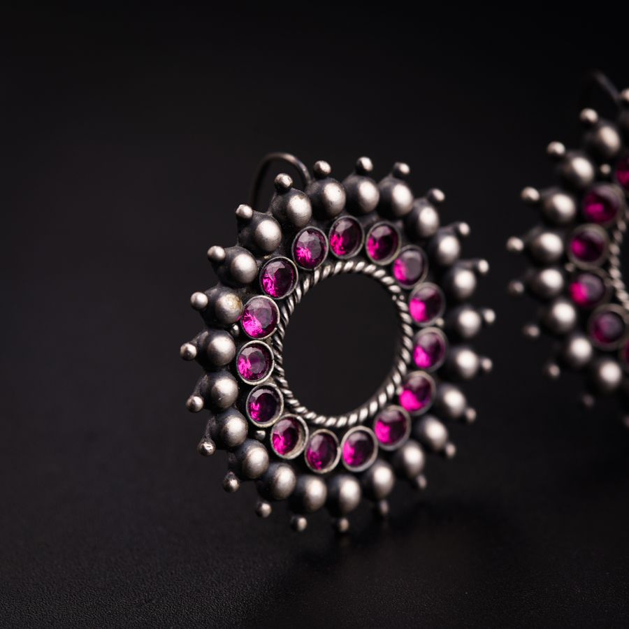 a close up of a pair of earrings on a black surface