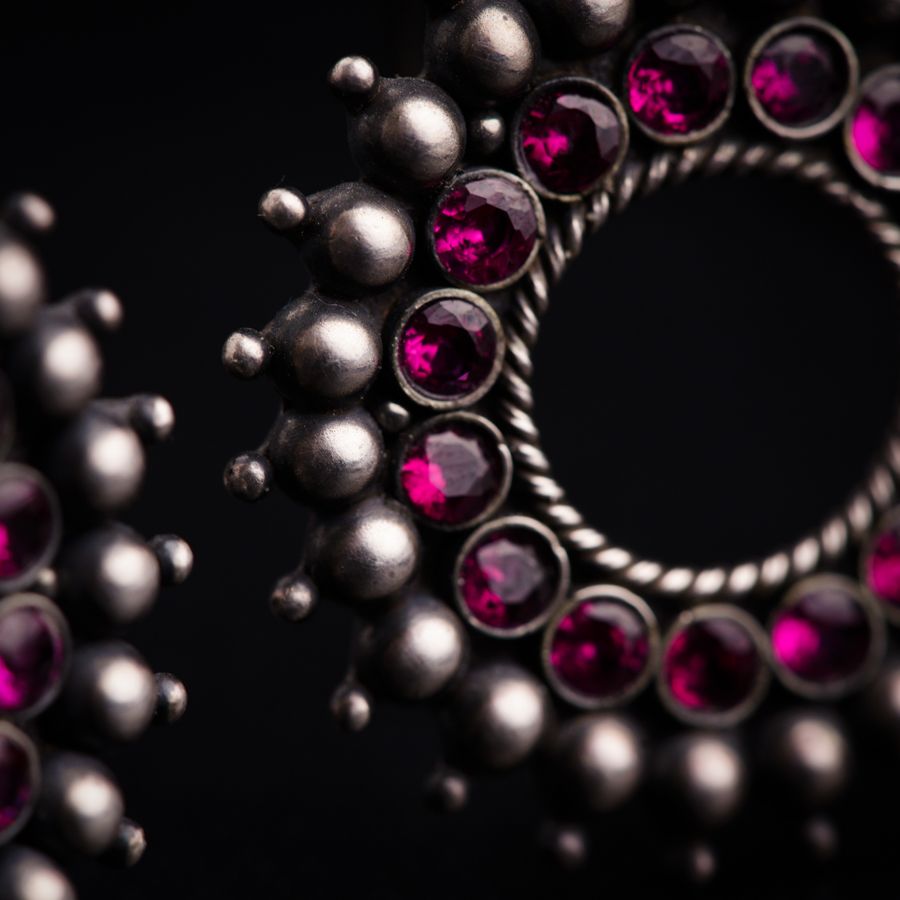 a close up of a metal object with pink stones