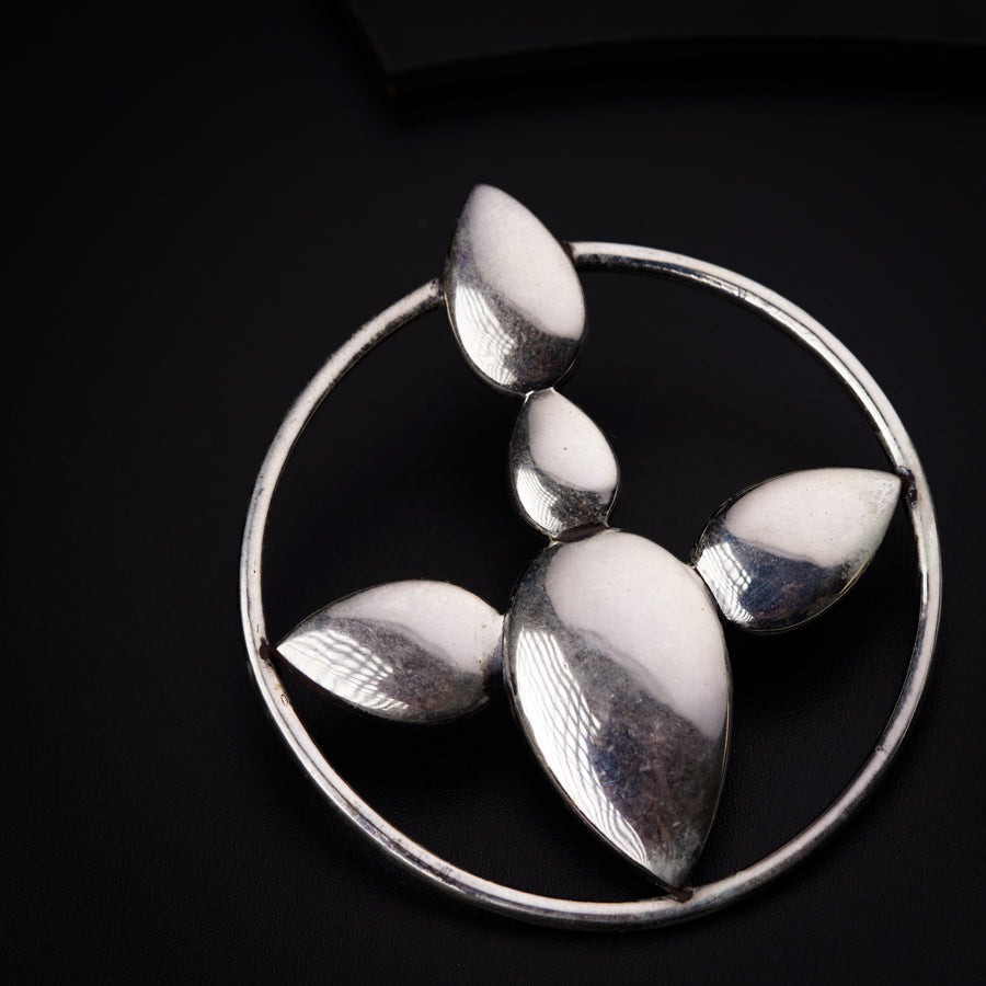 a silver brooch with three leaves on it