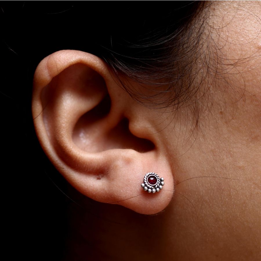 a close up of a person wearing a pair of ear piercings