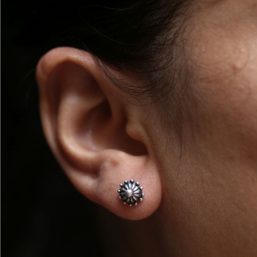 a close up of a person wearing a pair of earrings