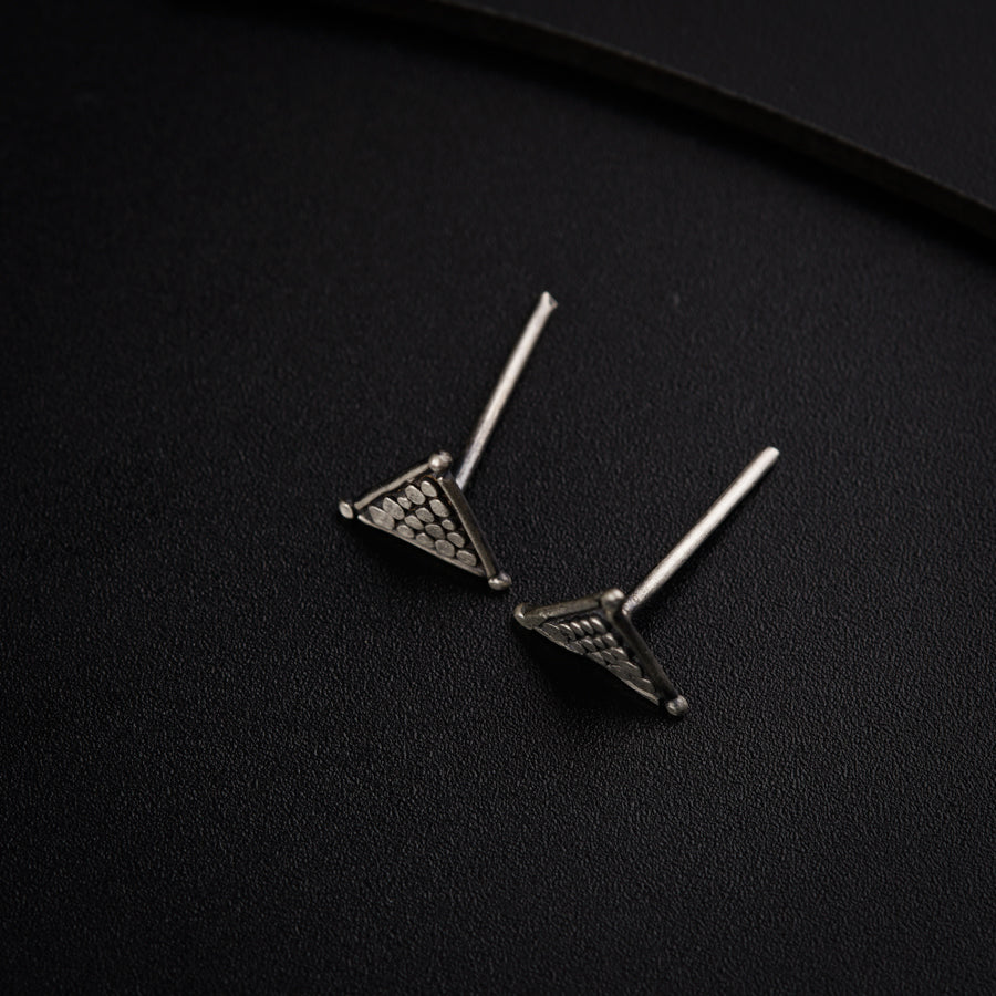 a pair of earrings sitting on top of a black surface