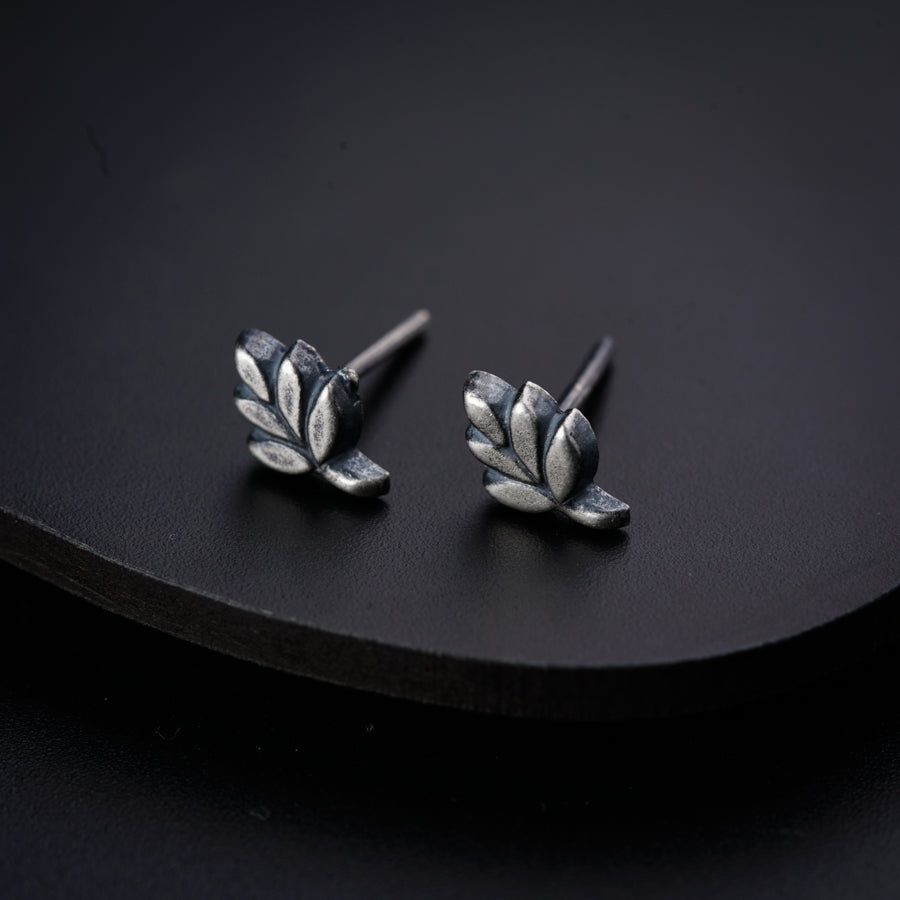 a pair of silver leaves on a black surface