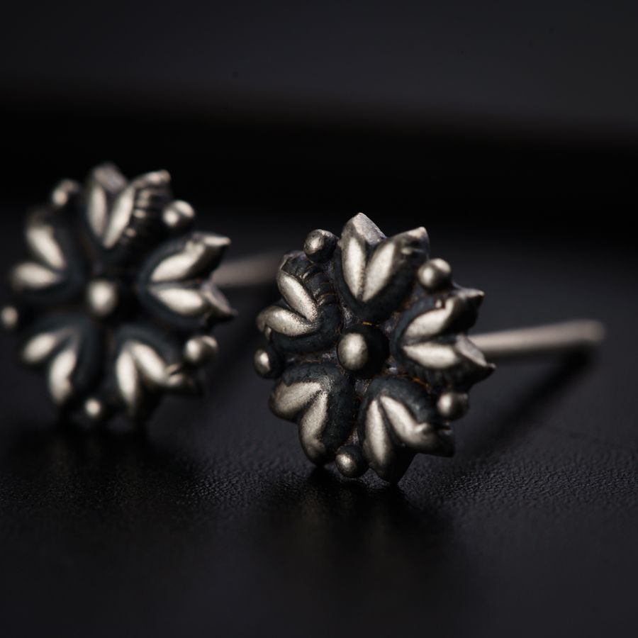 a pair of silver earrings sitting on top of a table