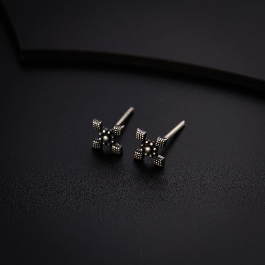 a pair of black and white earrings on a black surface
