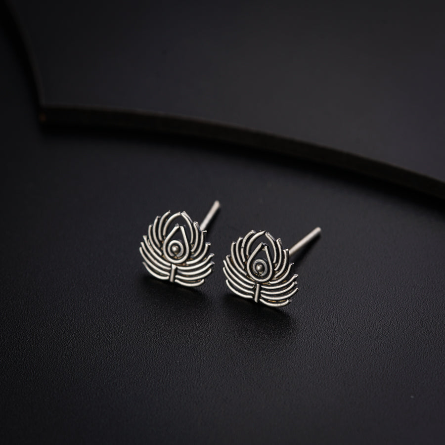 a pair of earrings sitting on top of a black surface