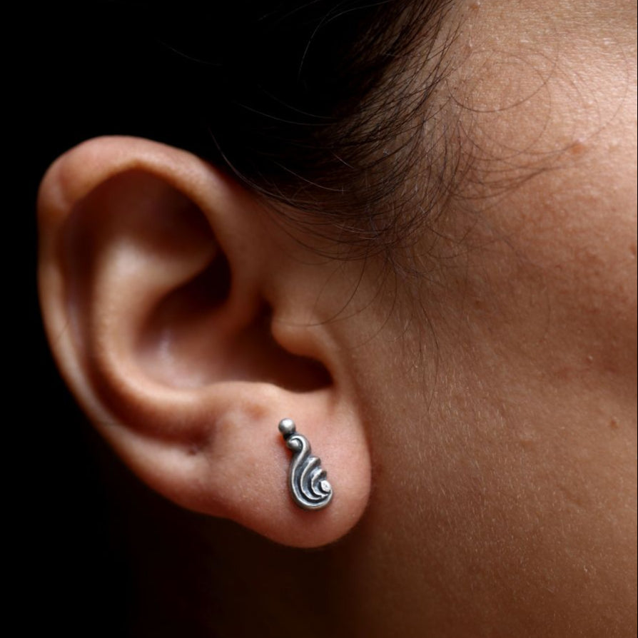 a close up of a person wearing a pair of ear piercings