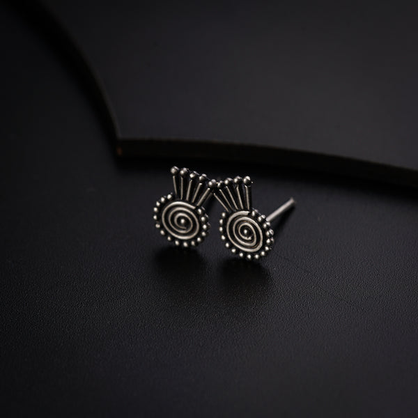 a pair of earrings sitting on top of a black surface