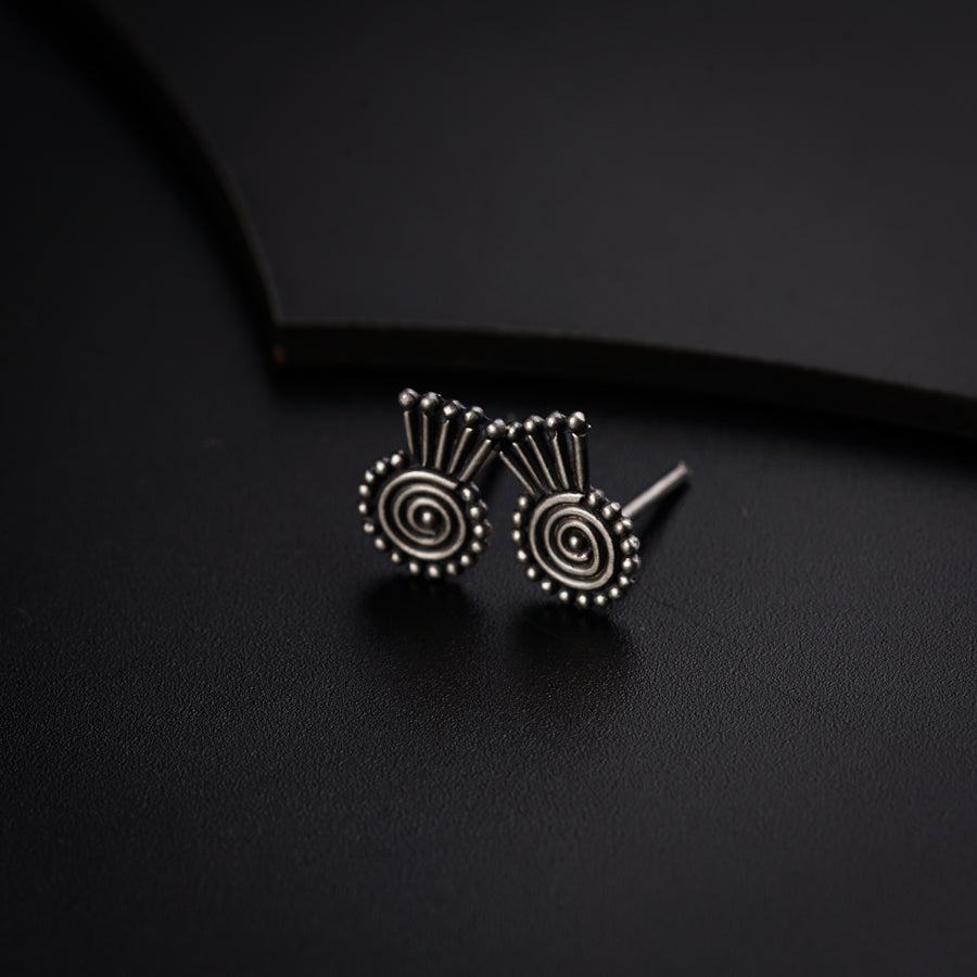 a pair of earrings sitting on top of a black surface