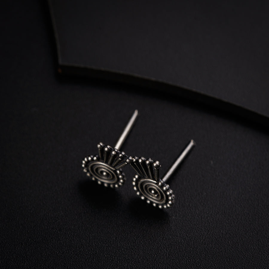 a pair of earrings sitting on top of a black surface