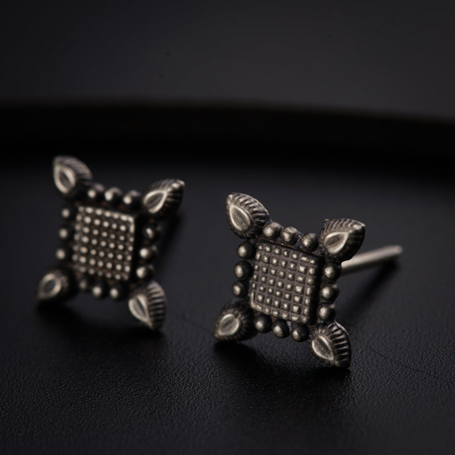 a pair of studded earrings sitting on top of a table