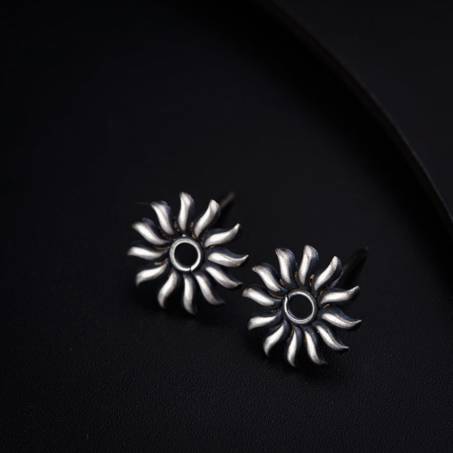 a pair of earrings sitting on top of a black surface