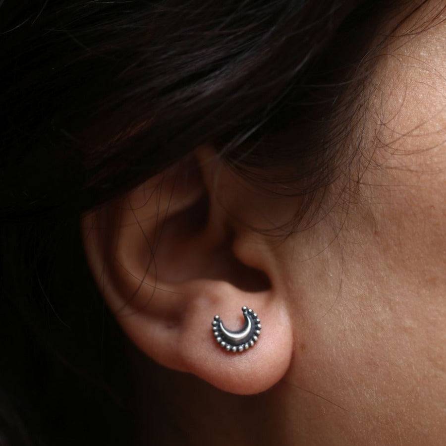 a close up of a person wearing a pair of ear piercings