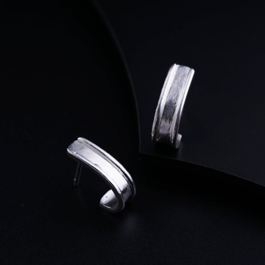 a pair of silver rings sitting on top of a black surface